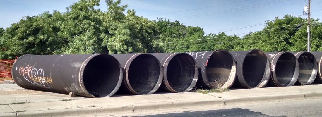 old steel casing pipes with graffiti on it